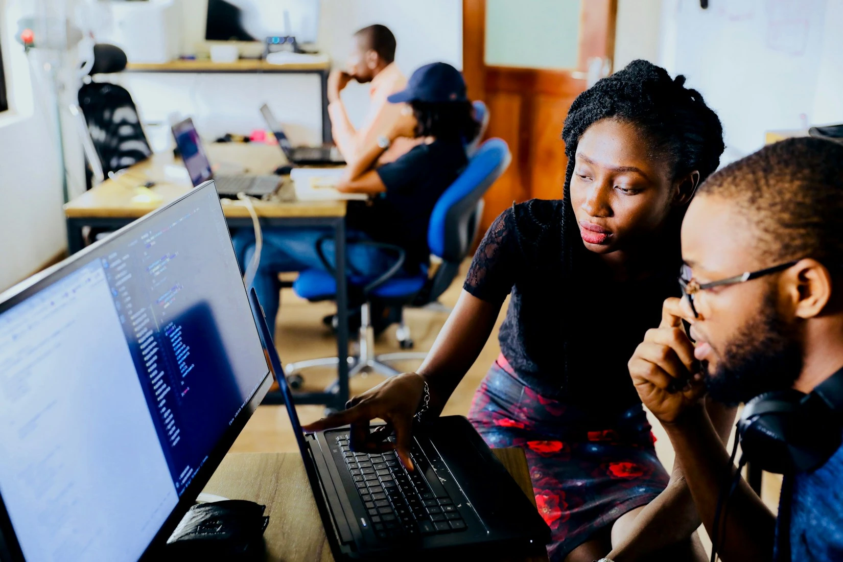 Et team arbejder med digitale opgaver ved deres computere.